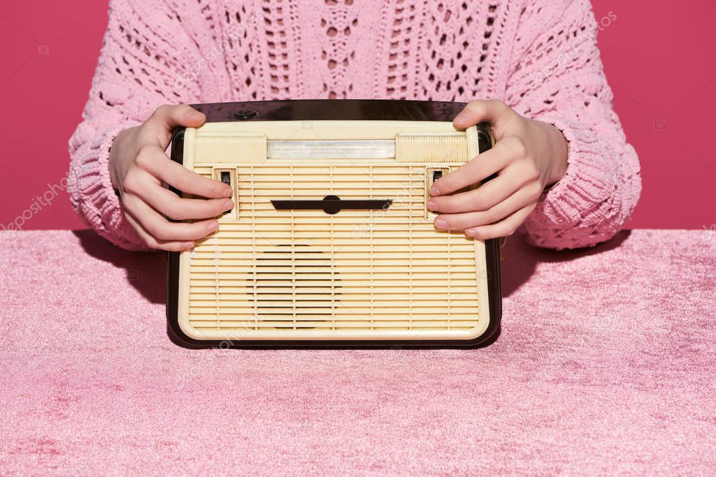 Reihe historischer Röhrenradios mit leuchtenden Skalen in einer Ausstellungsvitrine